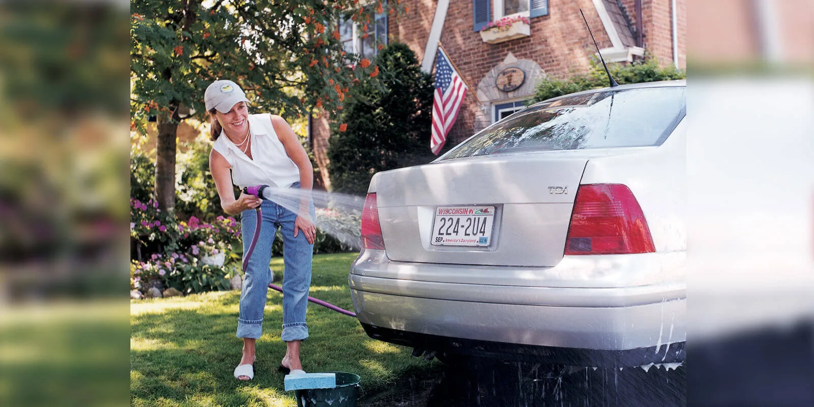 Washing a car on the lawn with a Dramm Revolver spray gun on a garden hose